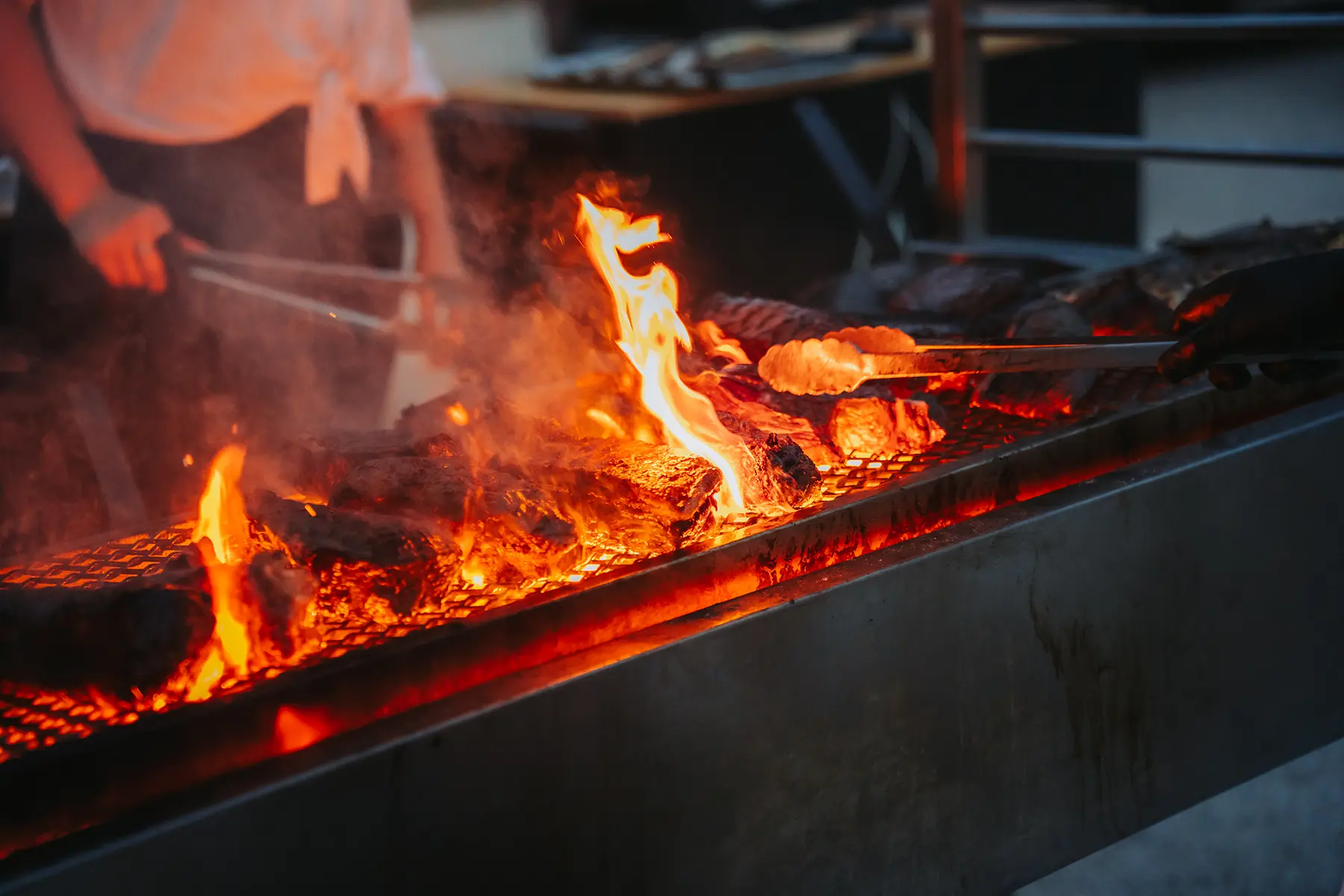 Aurélie & Jérémy 102 Pièces de viande en train de griller sur les flammes d'un grand barbecue professionnel