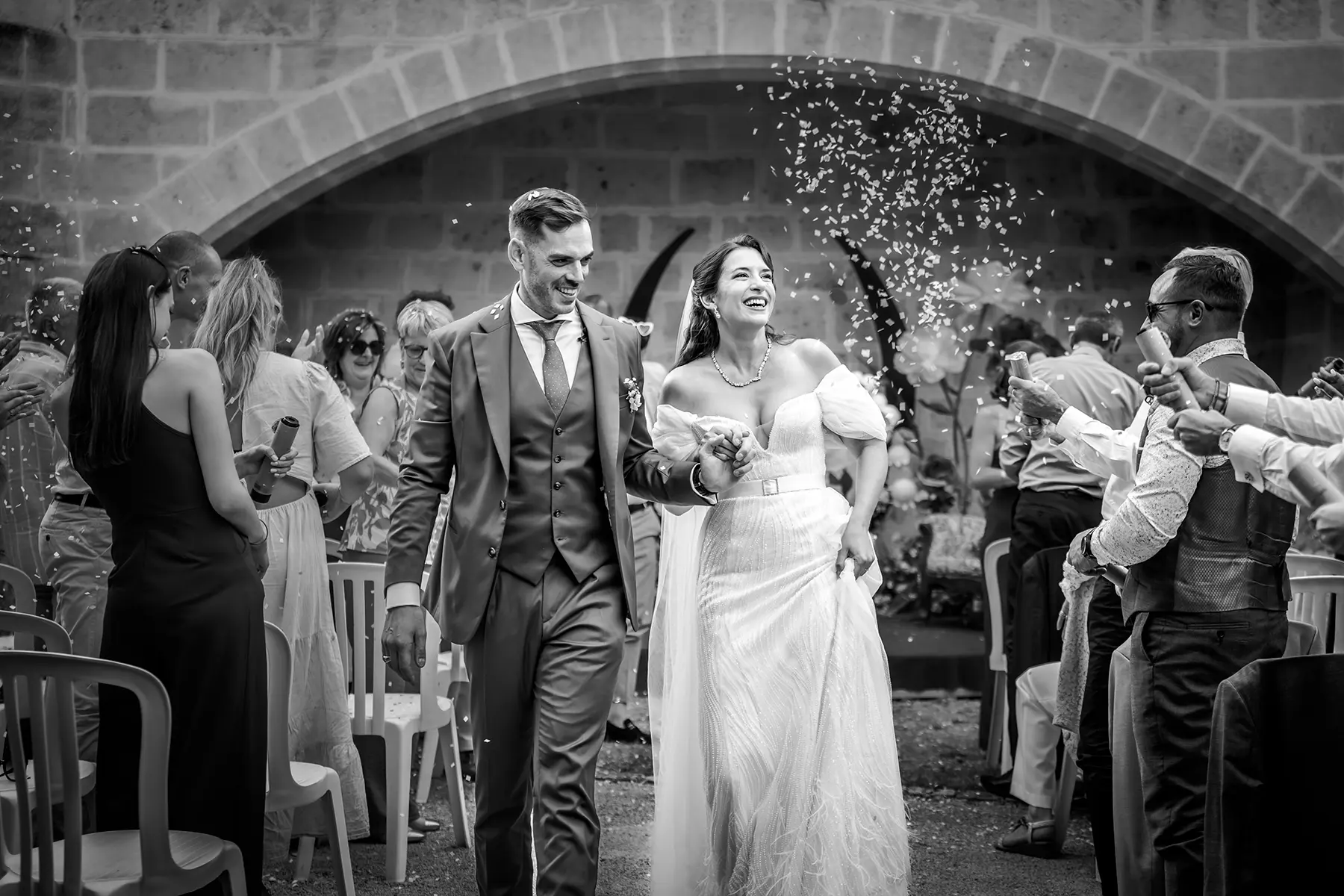 Aurélie & Jérémy 87 Mariés Aurélie et Jérémi souriants sous une pluie de confettis en sortie de cérémonie