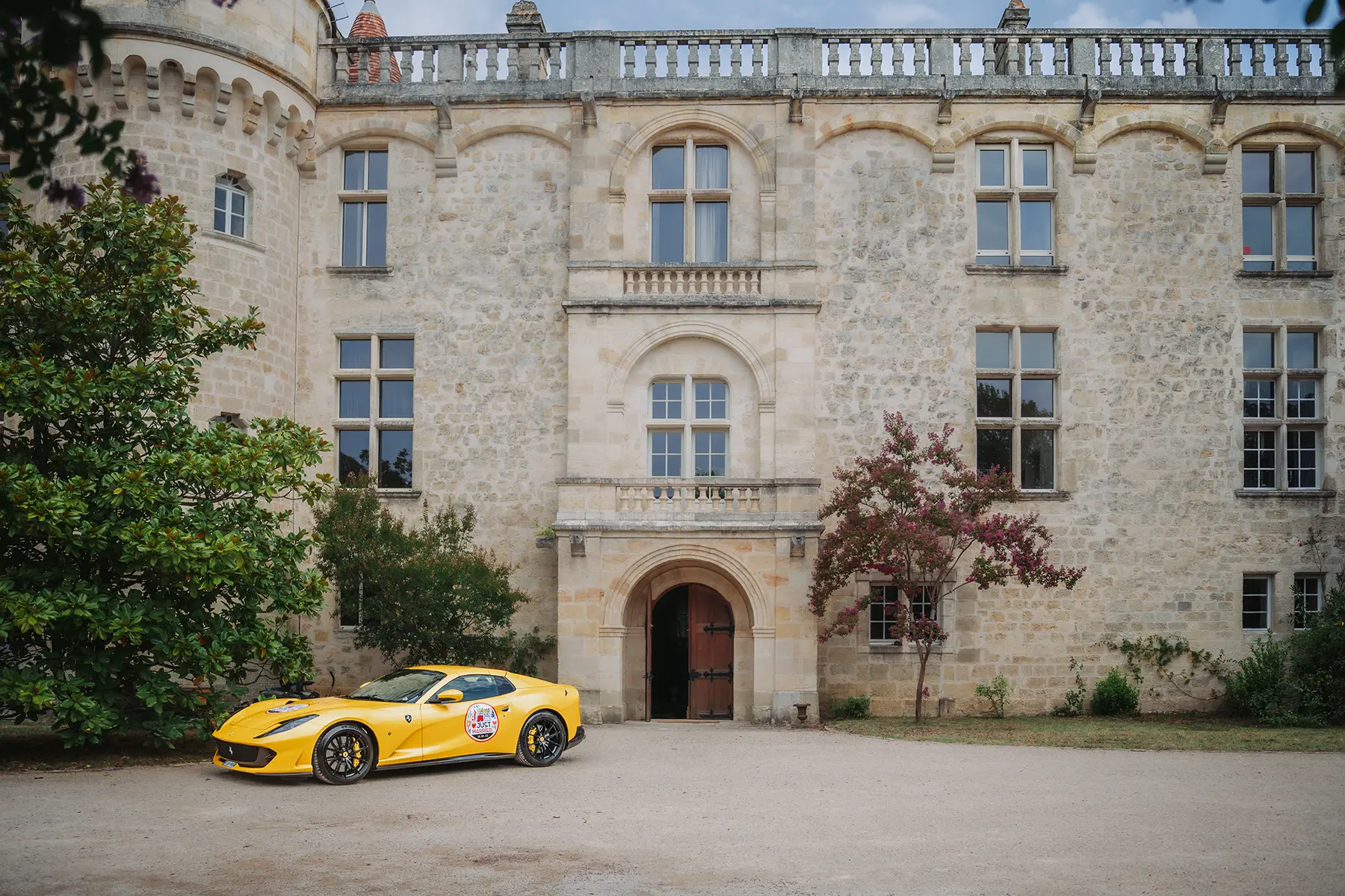 Aurélie & Jérémy 78 Ferrari jaune garée devant la façade en pierre du Domaine de la Dame Blanche